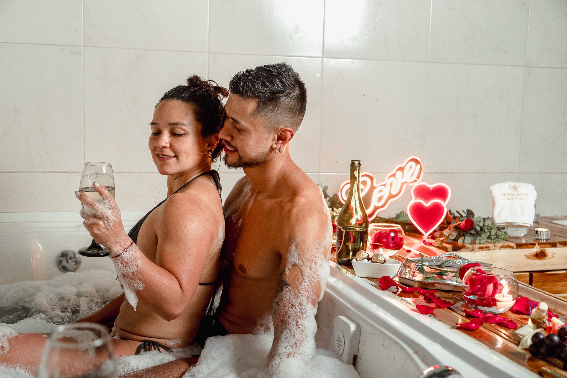 Pareja disfrutando el jacuzzi con copas y decoración romántica en Boyacá VIP